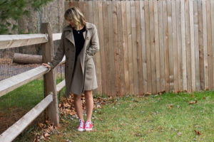 woman wearing chuck taylor all star sneakers with a pea coat