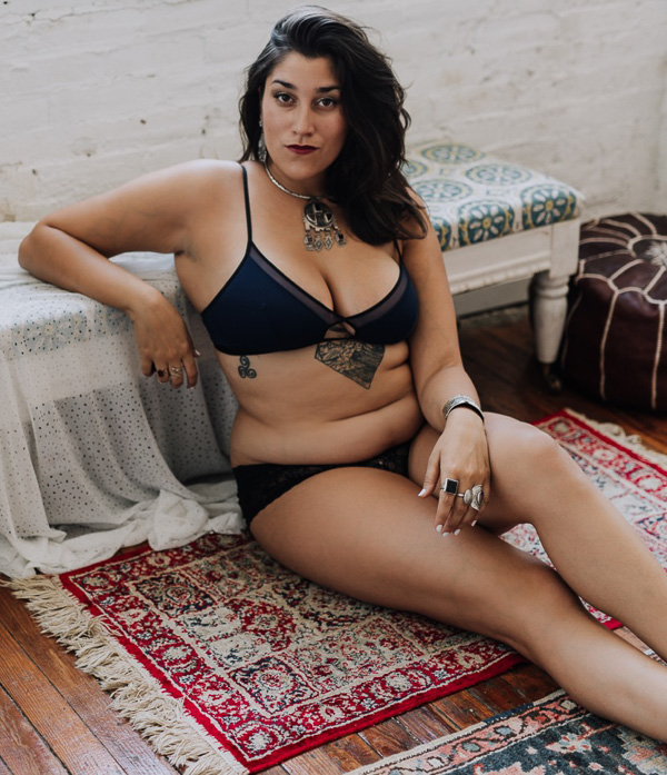 Cheyenne Gil, body positive boudoir photographer, posing in her studio. 